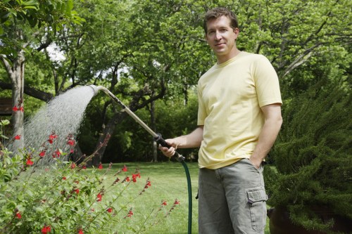 Professional gardener using shears for hedge trimming